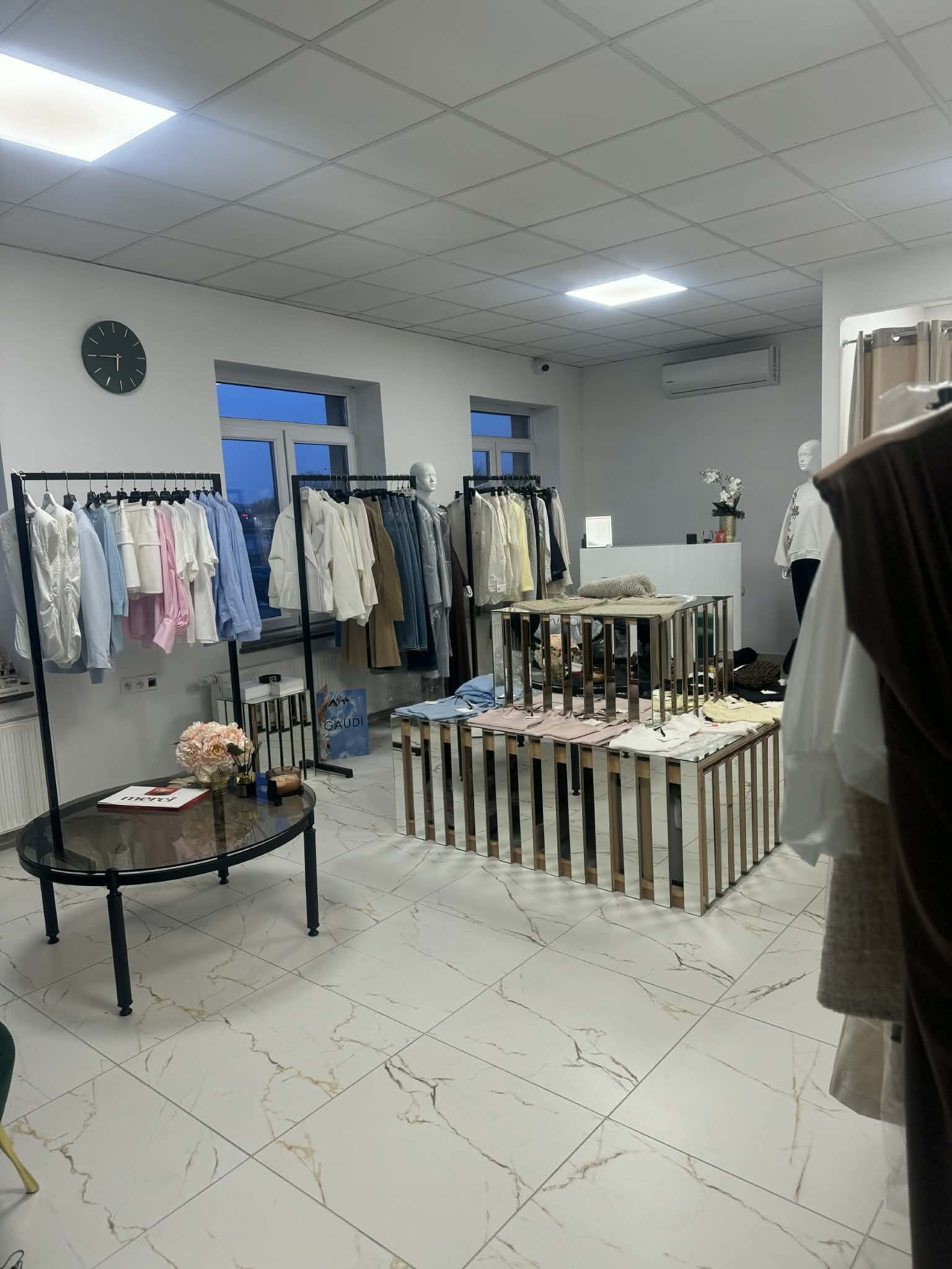 Wnętrze butiku MOORI — kolekcja włoskiej odzieży damskiej premium na wieszakach, elegancka przestrzeń z marmurową podłogą